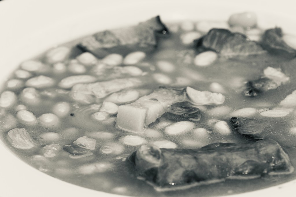 Soup with meat and vegetable in white ceramic bowl